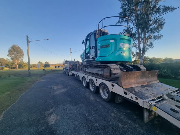 MJF excavator secured on a transport trailer